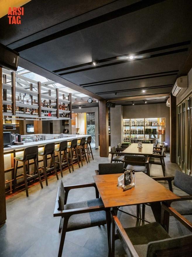Interior restoran dengan dinding kaca di bagian depan dan skylight di atas area cafe bar, karya Fiano via Arsitag