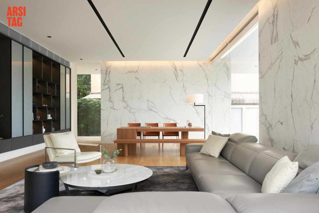 Desain open space dengan dinding marmer dan lantai kayu, serta sofa besar abu-abu, Karya A01 via Arsitag
