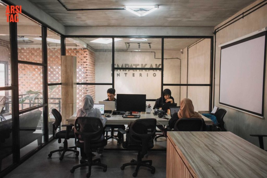Ruangan kantor AC dengan dinding kaca panel hitam dan lampu segitiga, karya Bintang Architects via Arsitag